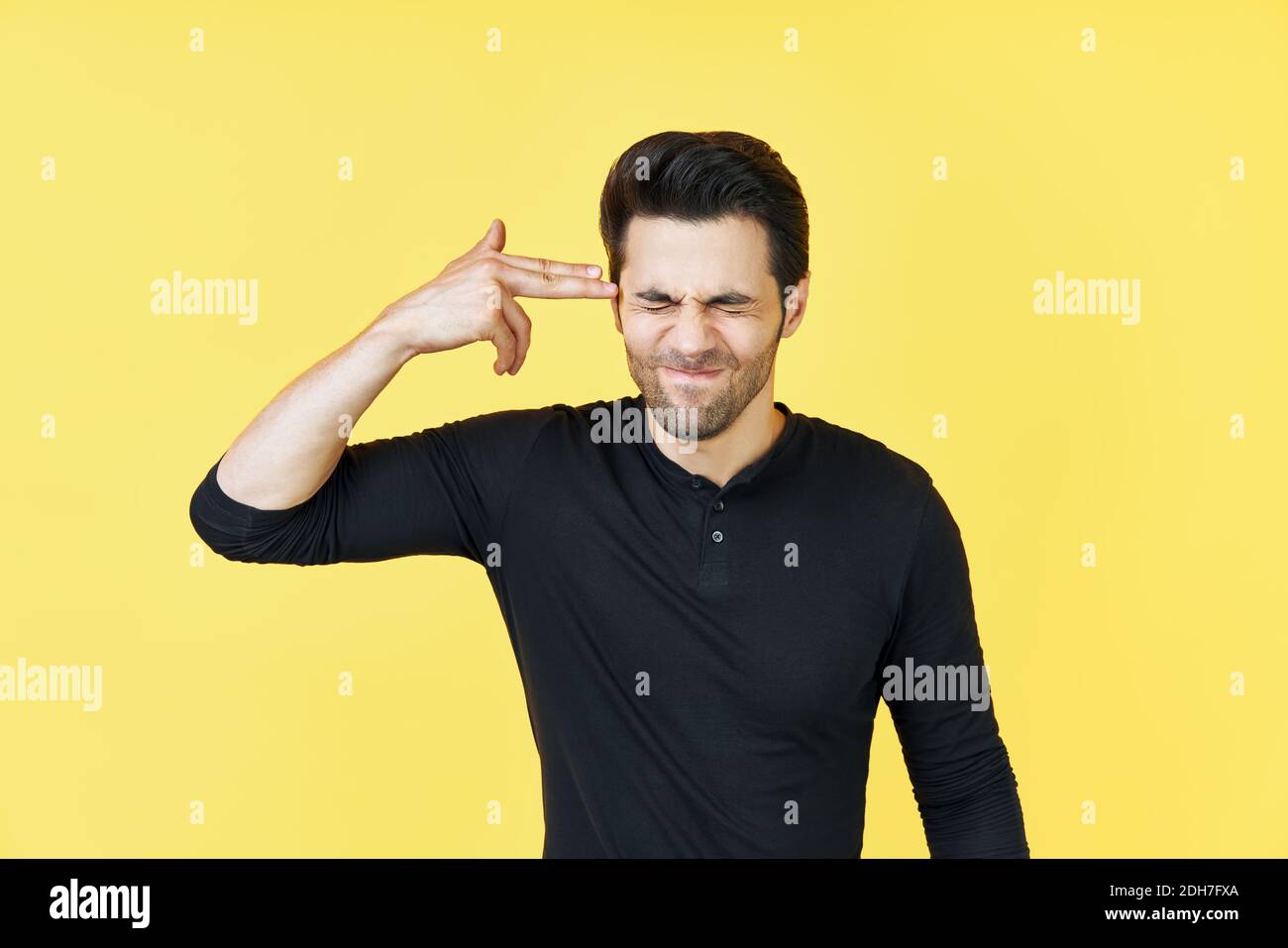 Junger Mann, der die Geste des Schießens selbst macht Stockfoto