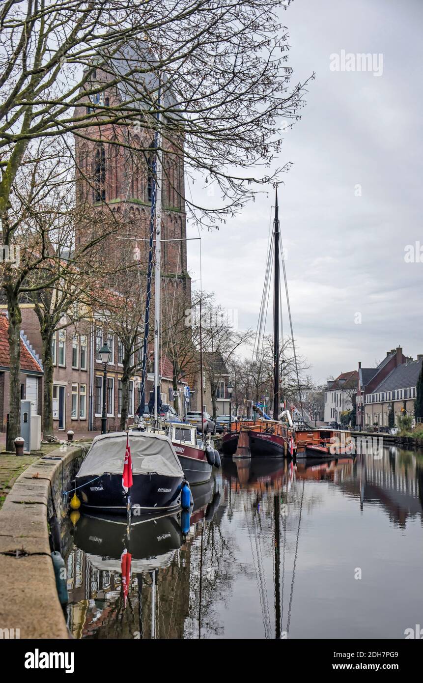 Oudewater, Niederlande, 6. Dezember 2020: Blick entlang des Kais der Hollandsche IJssel mit Boot und Yachten und im Hintergrund der Turm Stockfoto