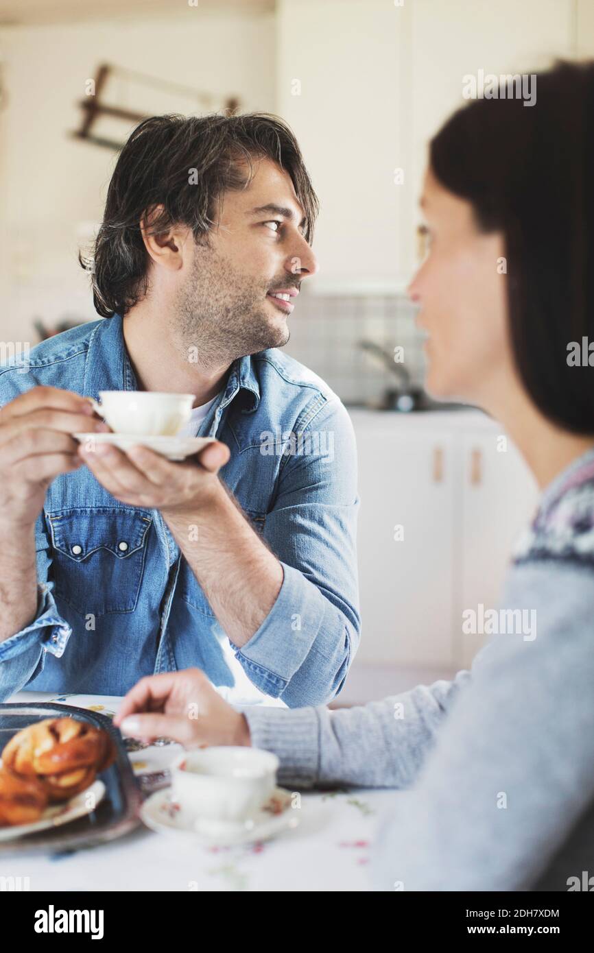Ein Mann mittleren Erwachsenen, der Kaffee mit einer Frau am Frühstückstisch getrunken hat Stockfoto Ein Mann mittleren Erwachsenen, der Kaffee mit einer Frau am Frühstückstisch getrunken hat Stockfoto