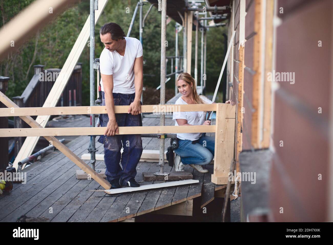 Volle Länge des Paares arbeiten auf der Veranda des Hauses sein Renoviert Stockfoto