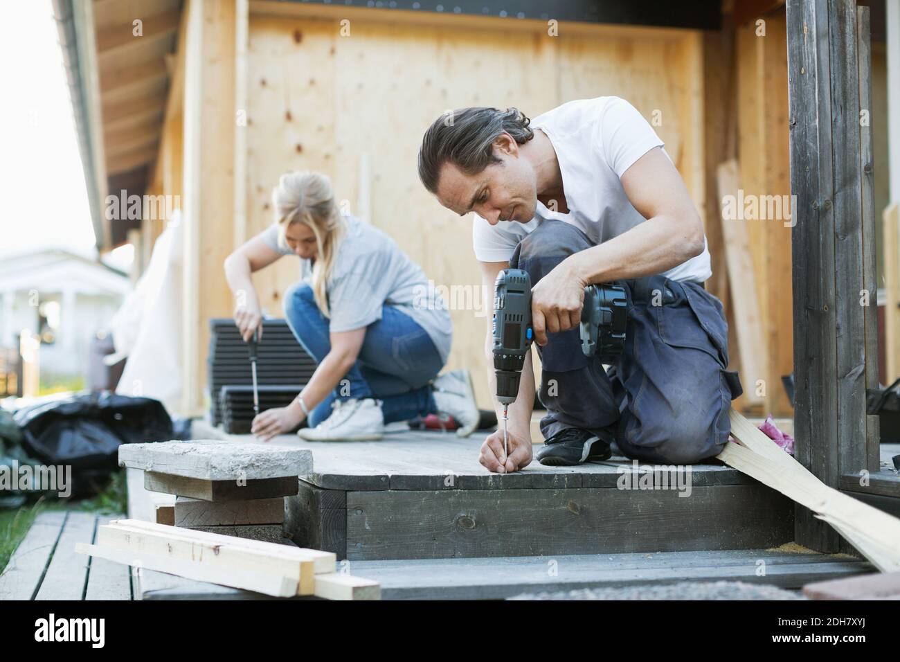 Paar arbeiten außerhalb des Hauses während der Hausverbesserung Stockfoto