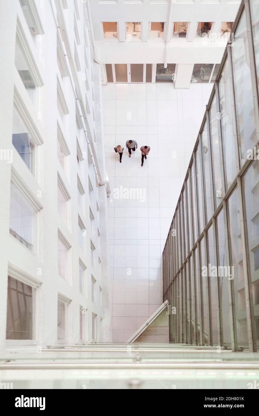 Entferntes Bild von Geschäftsleuten, die in einem modernen Büro herumlaufen Stockfoto