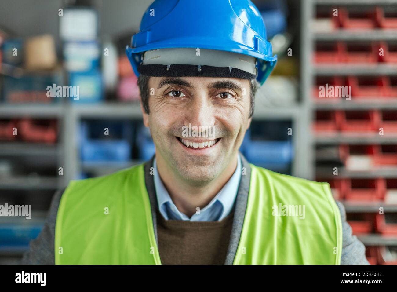 Porträt von glücklich reifen Arbeiter tragen Hardhat in der Fabrik Stockfoto