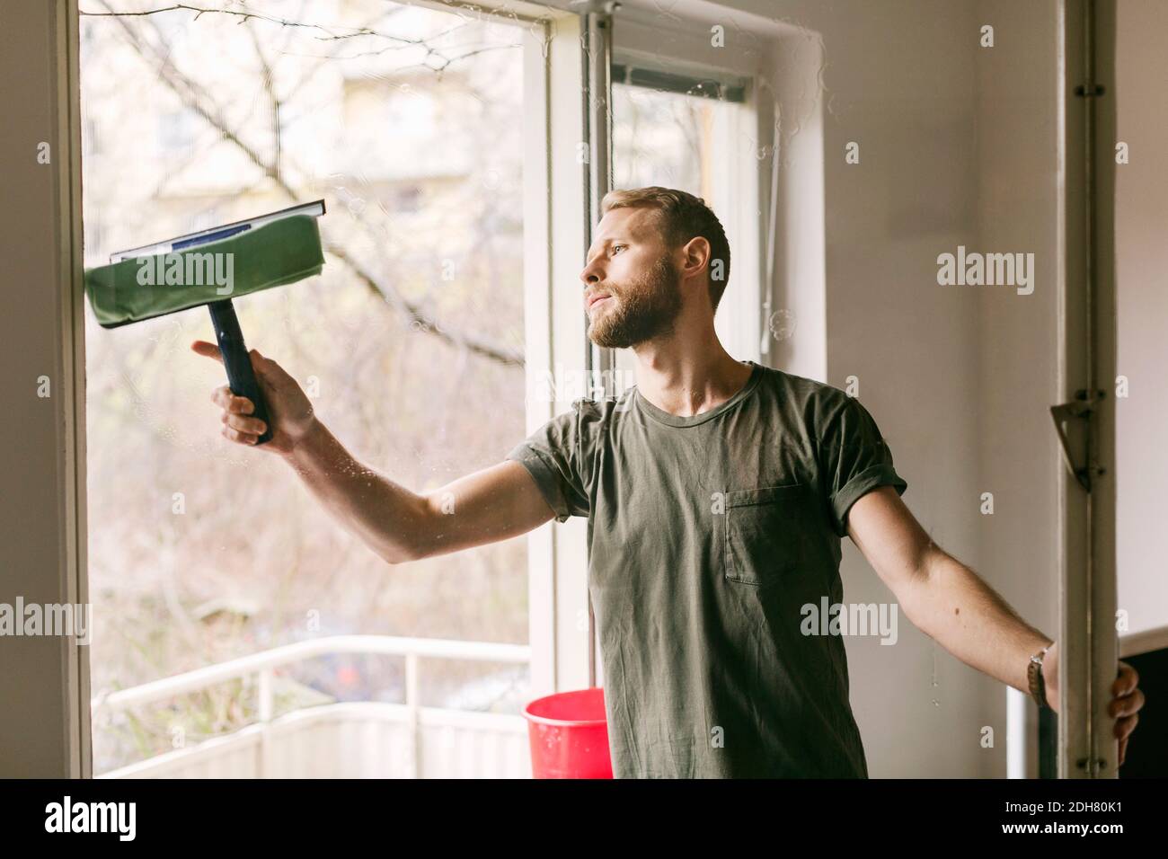 Mann, der Glasfenster putzt Stockfoto
