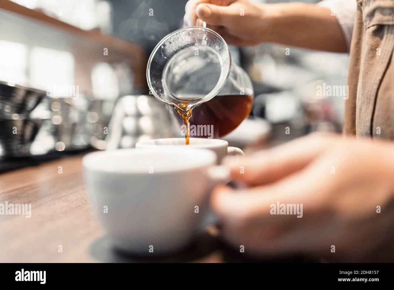 Zugeschnittenes Bild vom Barista, der am Tresen Kaffee zubereitet Stockfoto