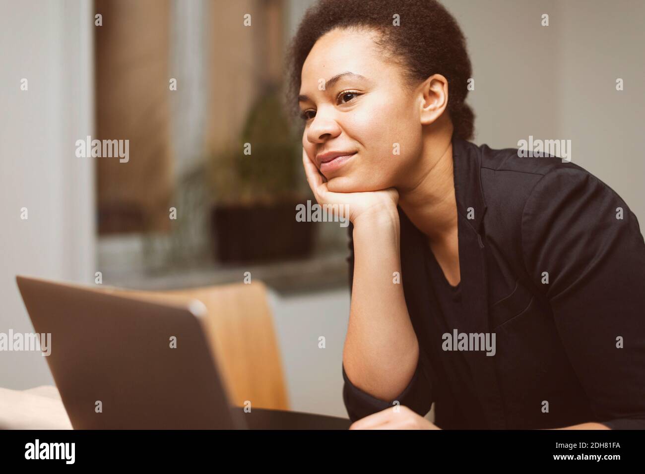 Nachdenklich Geschäftsfrau mit Hand am Kinn im Büro Stockfoto