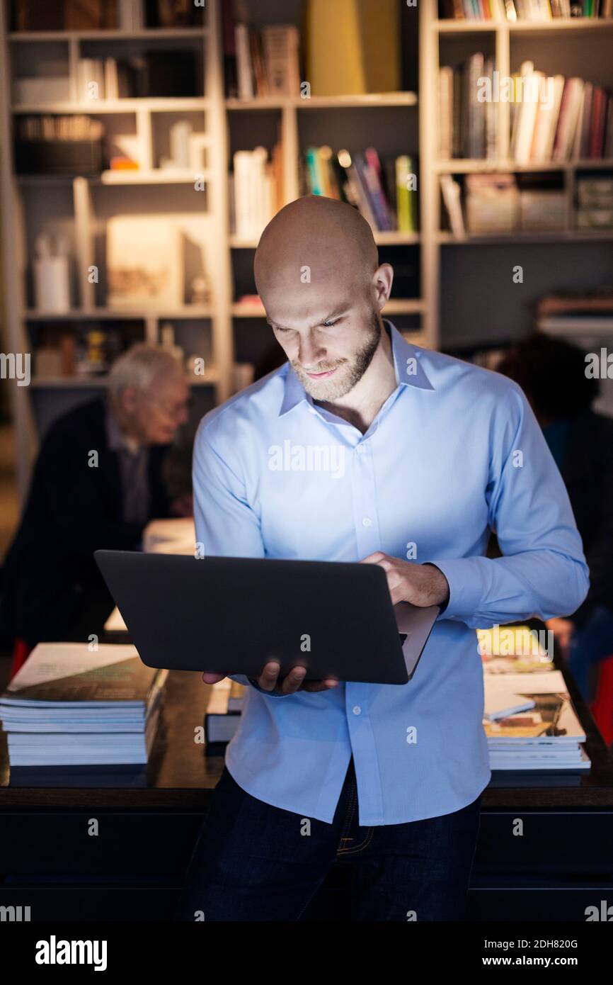 Junger Geschäftsmann mit Laptop im Büro Stockfoto