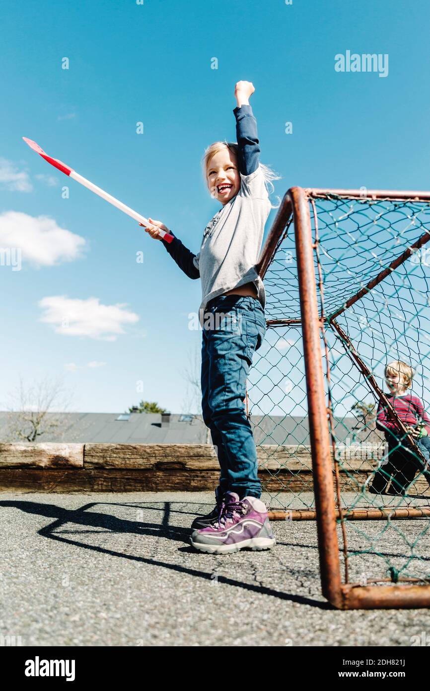 Low-Winkel-Ansicht der erfolgreichen Mädchen hält Hockey-Stick gegen Blauer Himmel Stockfoto