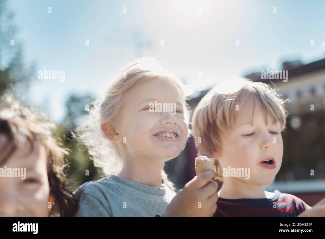 Blick aus der unteren Ecke auf Freunde, die Eis auf dem Hof essen An sonnigen Tag Stockfoto