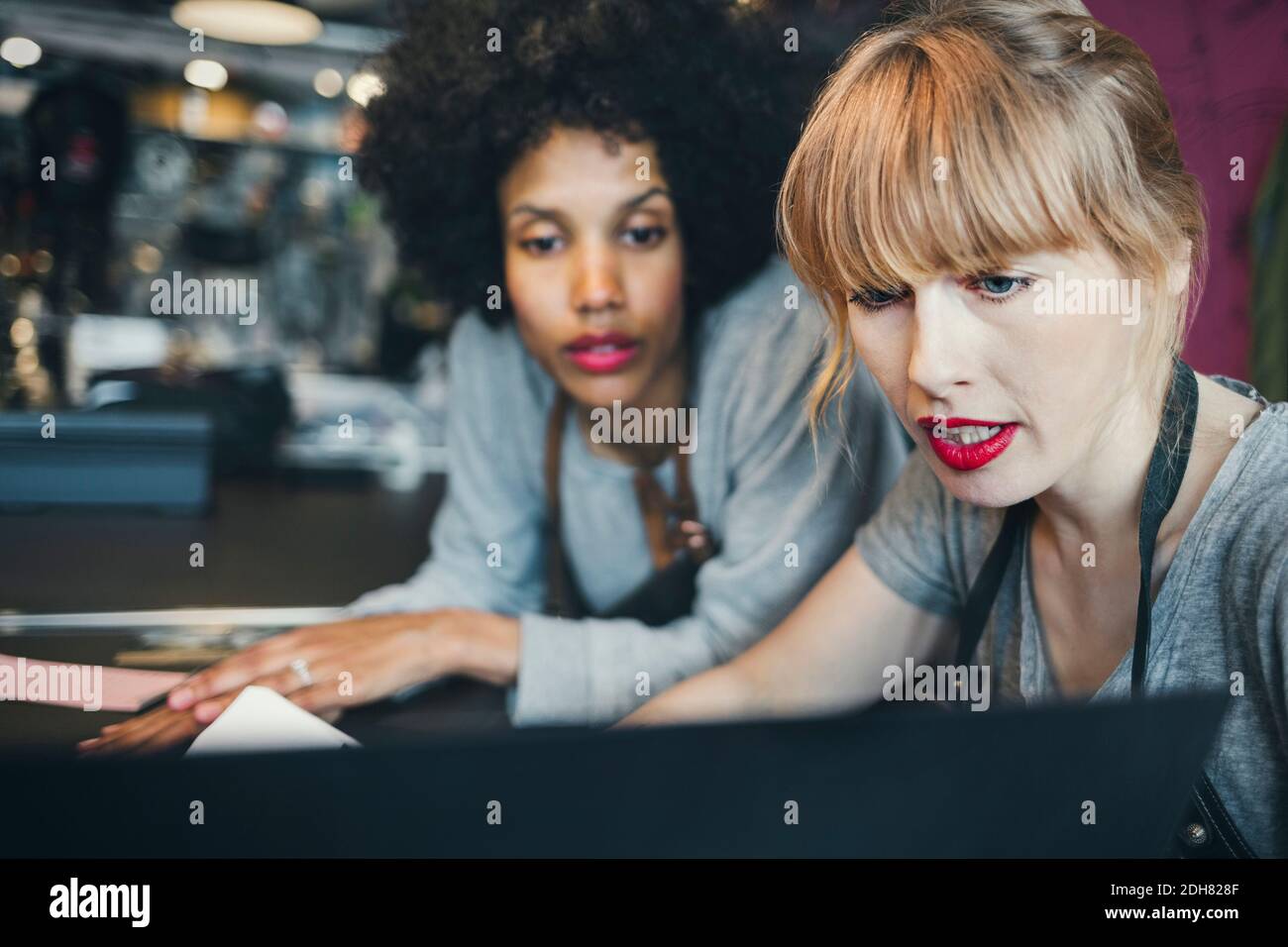 Mittlere Erwachsene weibliche Mechaniker mit Laptop in der Werkstatt Stockfoto