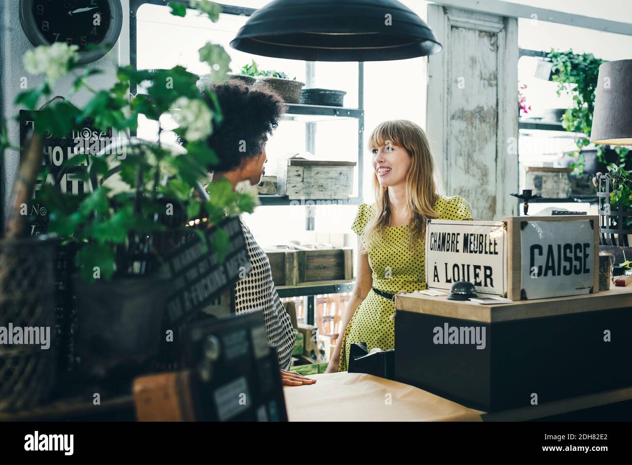 Weibliche Angestellte mittlerer Erwachsenen, die im Geschäft kommunizieren Stockfoto