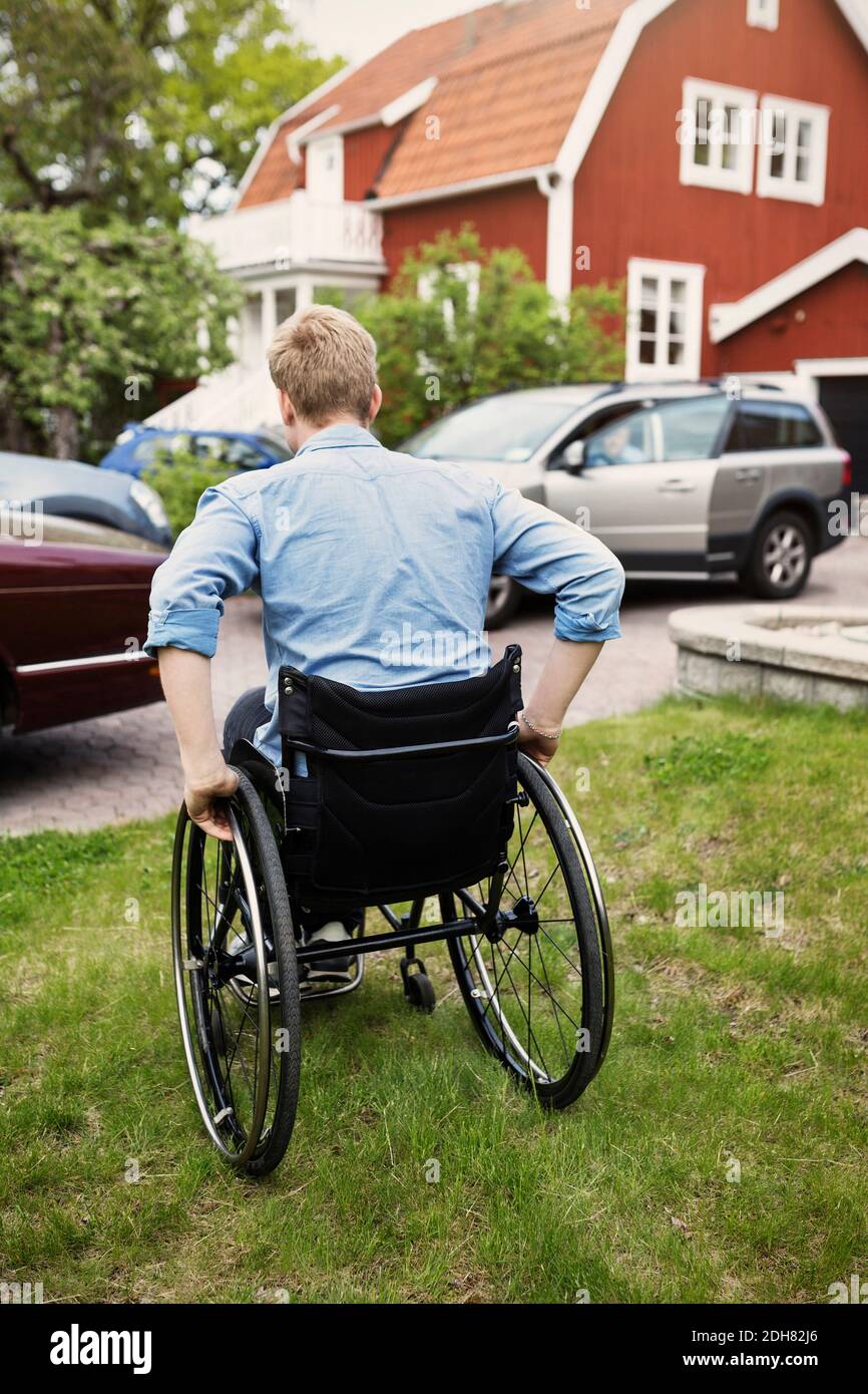 Rückansicht des Rollstuhlfahrers auf dem Hof Stockfoto