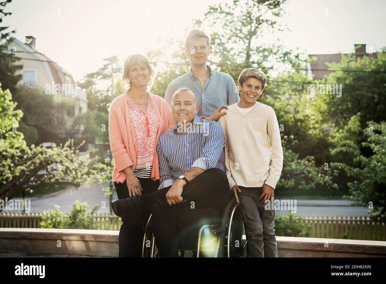 Porträt eines glücklichen behinderten Mannes mit Familie auf dem Hof Stockfoto