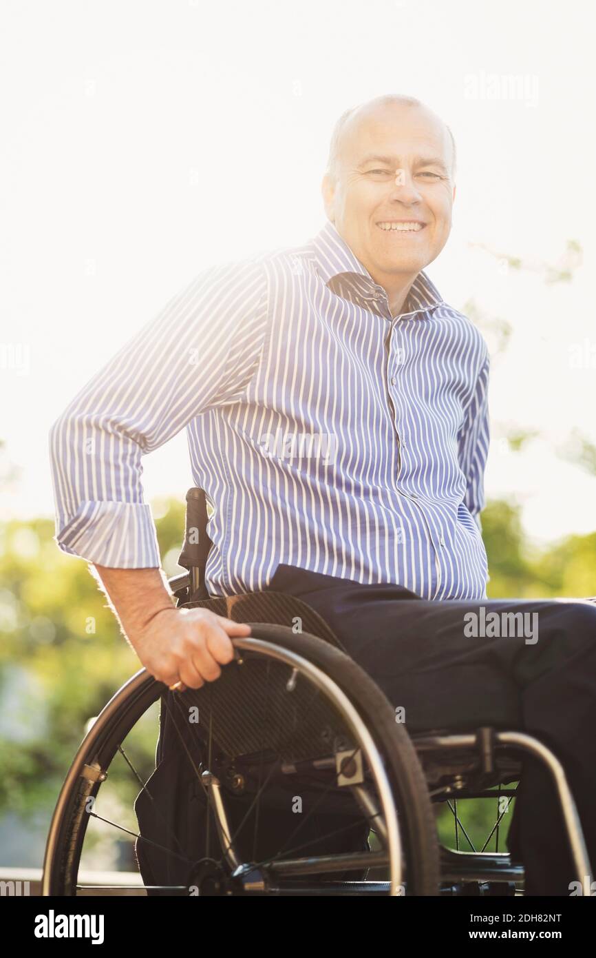 Portrait von glücklichen Mann im Rollstuhl sitzen im Freien Stockfoto