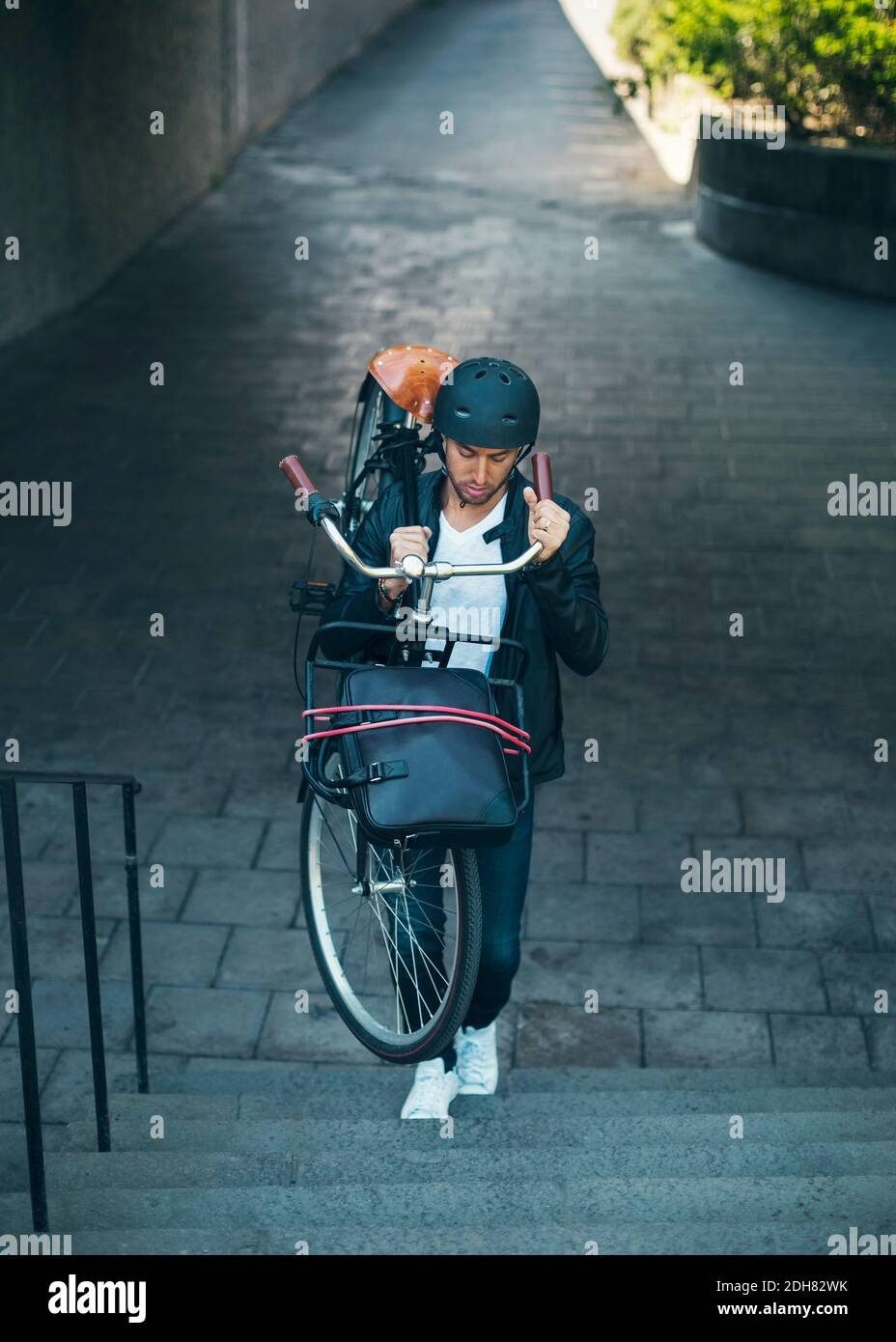 Geschäftsmann mit Fahrrad, während die Treppe hinauf Stockfoto