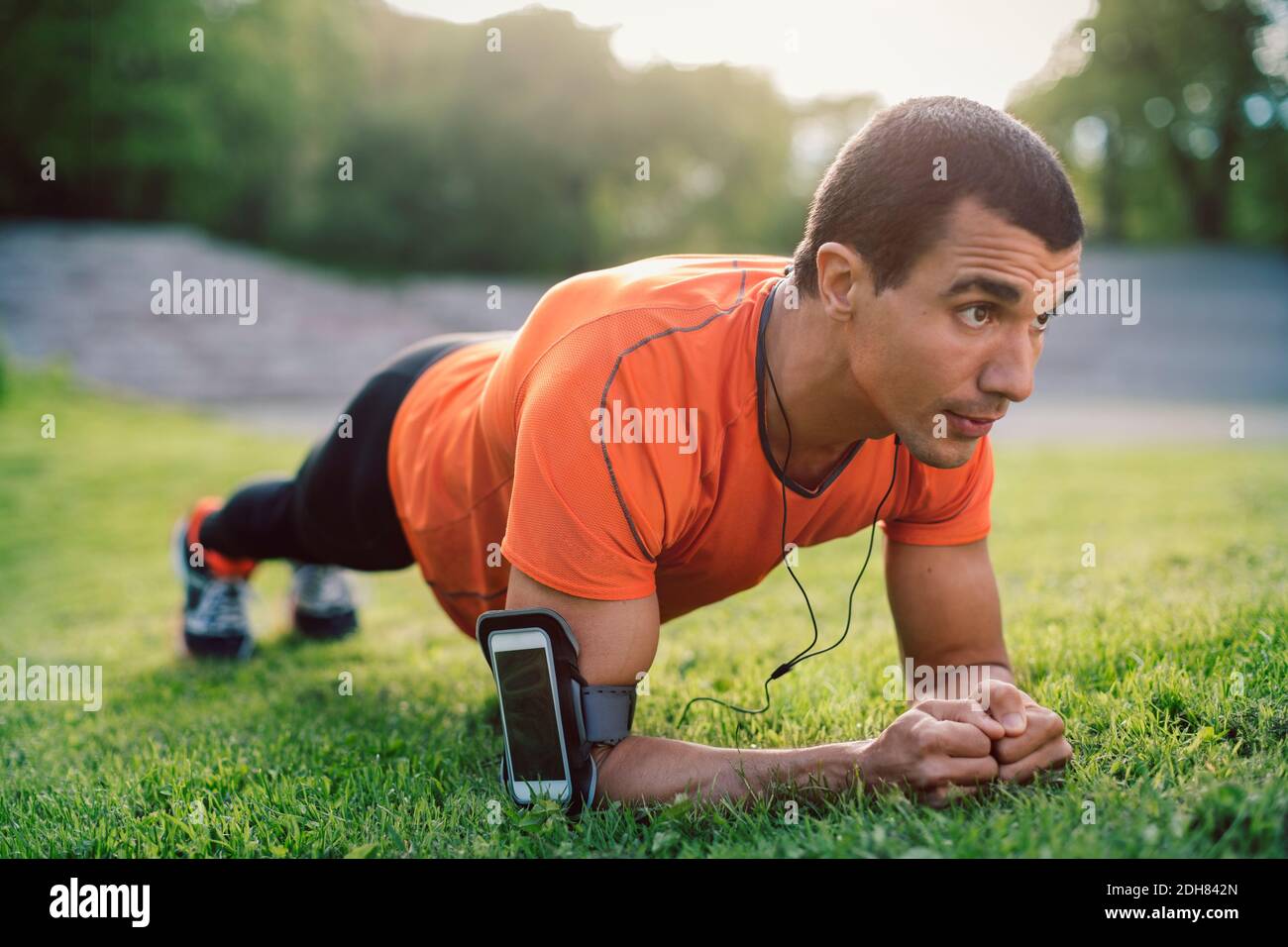 Mann, der Plank-Übung auf dem Rasen im Park macht Stockfoto