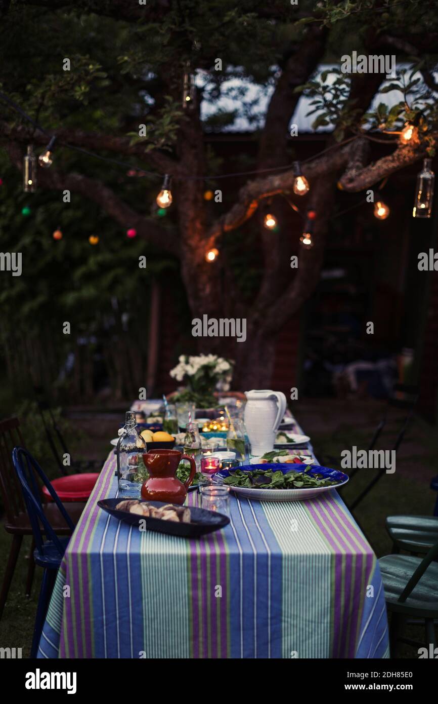 Das Essen wird auf dem Esstisch für die Abendparty im Hof serviert Stockfoto