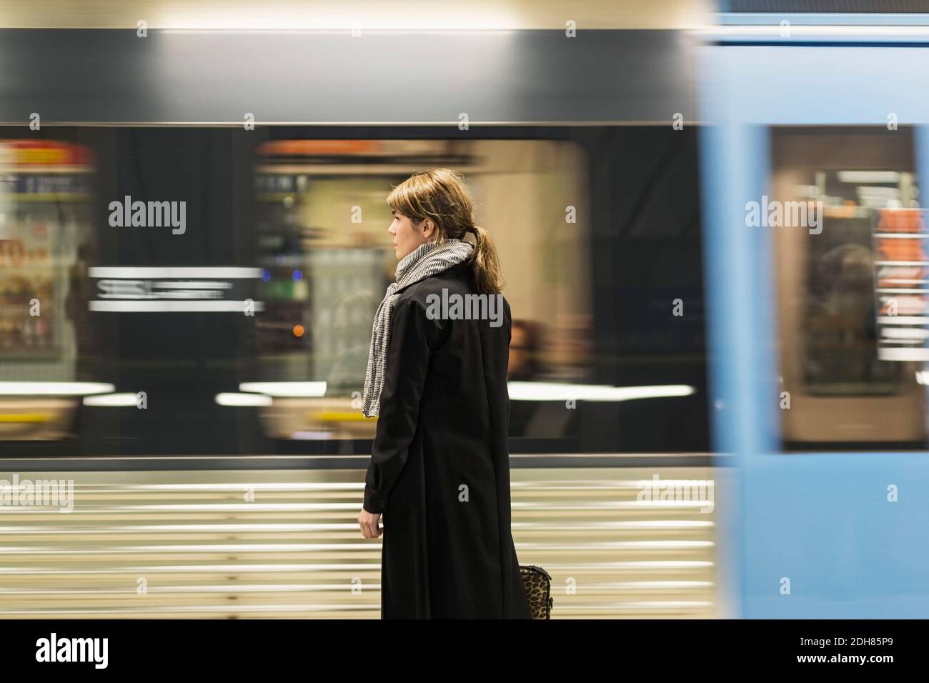 Junge Passagierin, die am Bahnhofsplatz steht Stockfoto