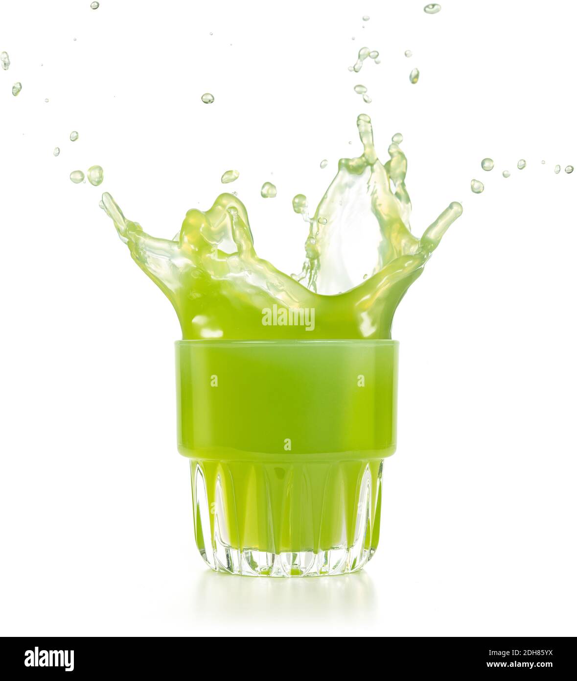 Grüner Saft explodiert aus einem Glas isoliert auf weiß Stockfoto