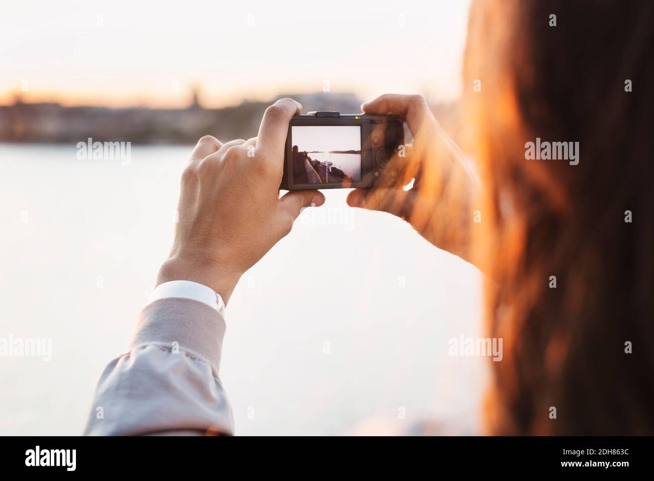 Zugeschnittenes Bild von touristischen Fotografie durch Digitalkamera gegen klare Himmel Stockfoto