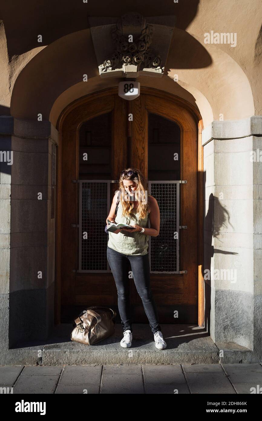Weibliche Touristenführer beim Lesen, während sie vor der Tür stehen Stockfoto