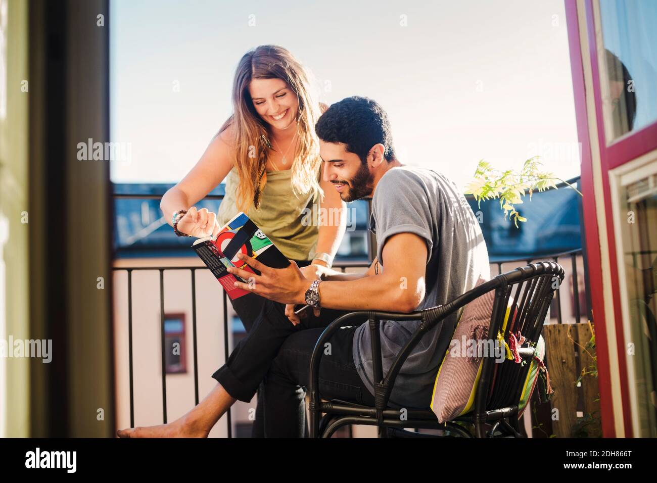 Ein Paar liest zusammen den Reiseführer auf dem Balkon Stockfoto