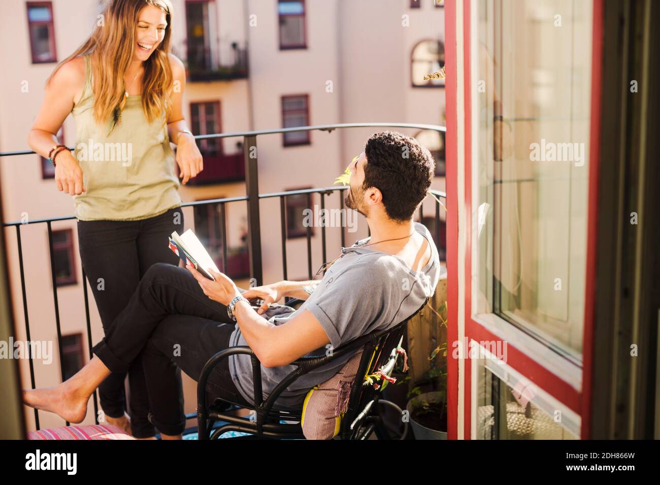 Ein glückliches Paar mit einem Reiseführer, der einen Urlaub auf dem Balkon plant Stockfoto