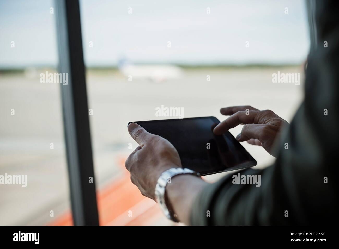 Zugeschnittenes Bild von Geschäftsmann mit digitalen Tablet am Flughafen Stockfoto