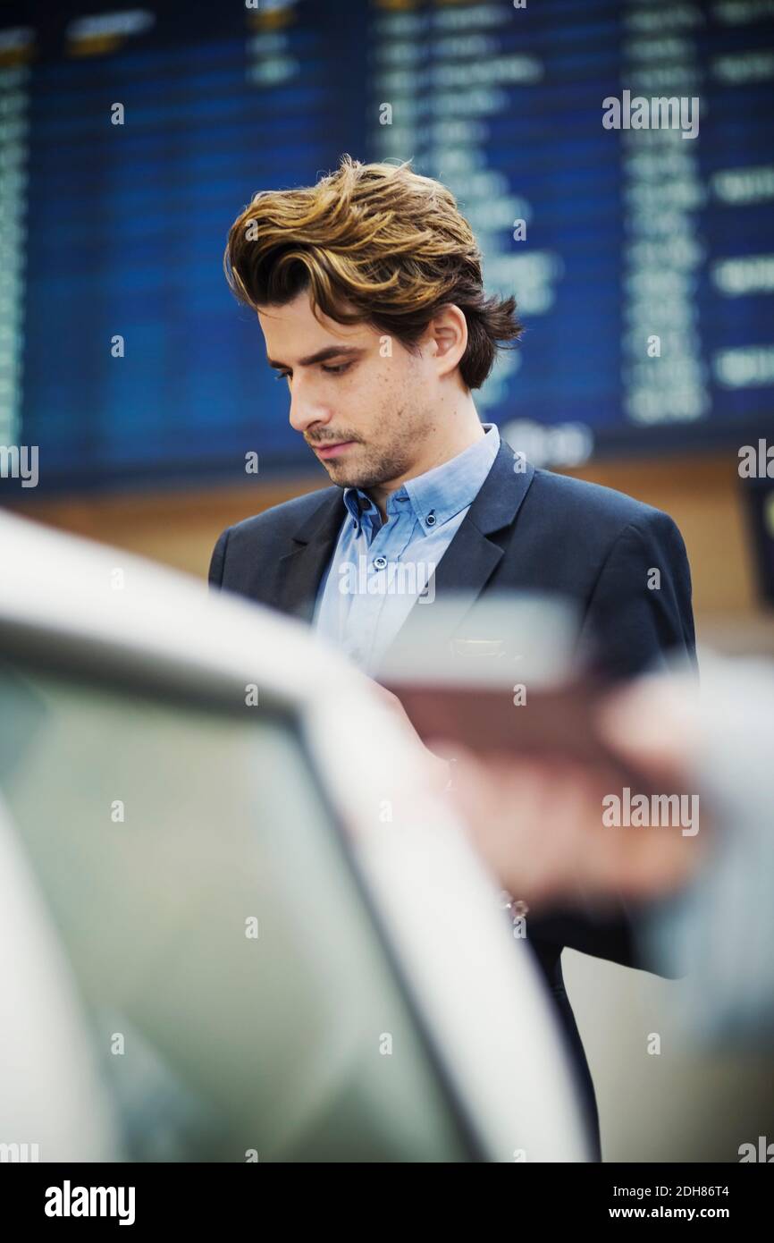 Ein Geschäftsmann steht am Check-in-Schalter am Flughafen Stockfoto