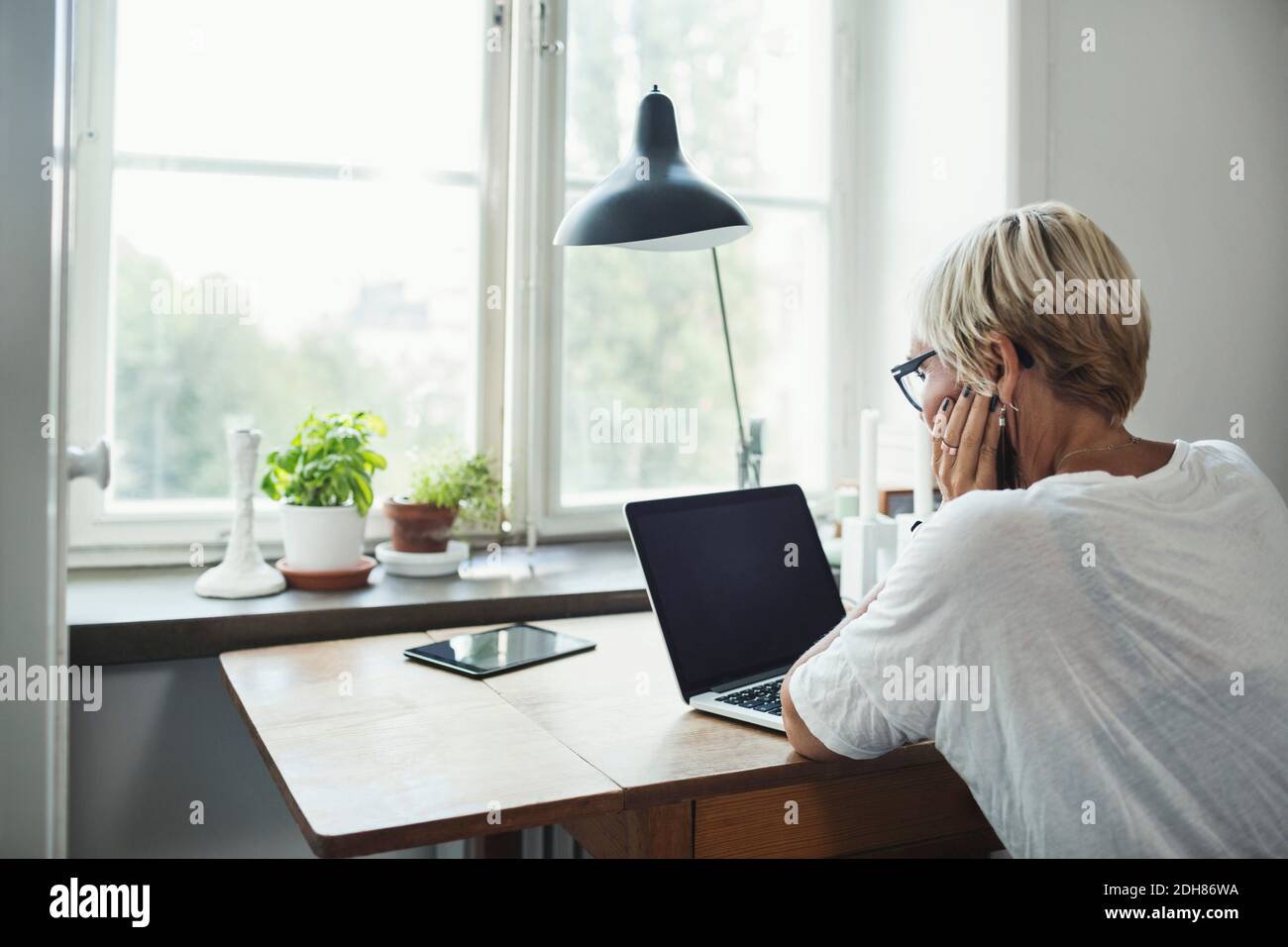 Rückansicht eines Industriedesigners, der im Home Office einen Laptop verwendet Stockfoto