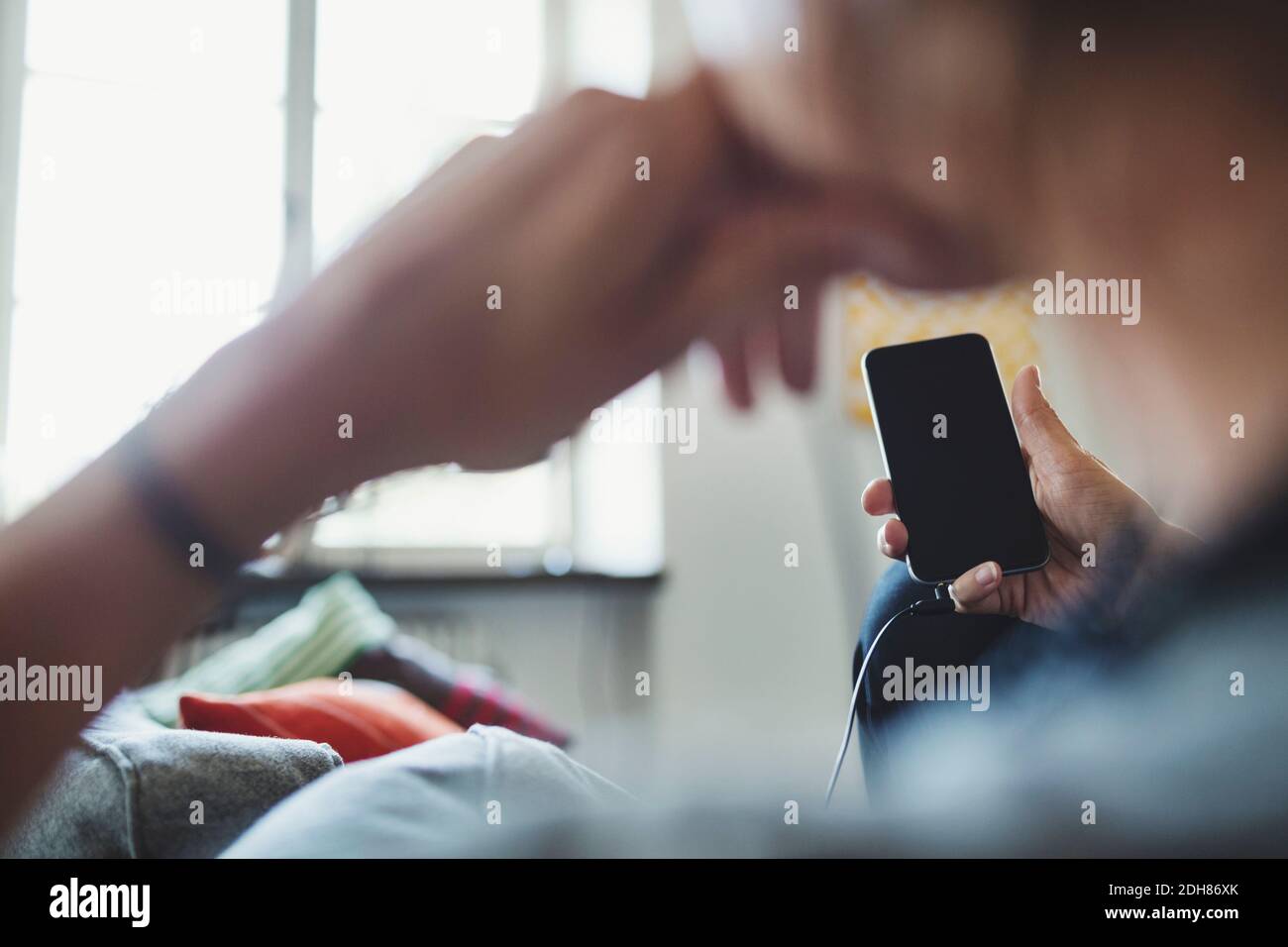 Beschnittenes Bild des Architekten, der Smartphone zu Hause hält Stockfoto