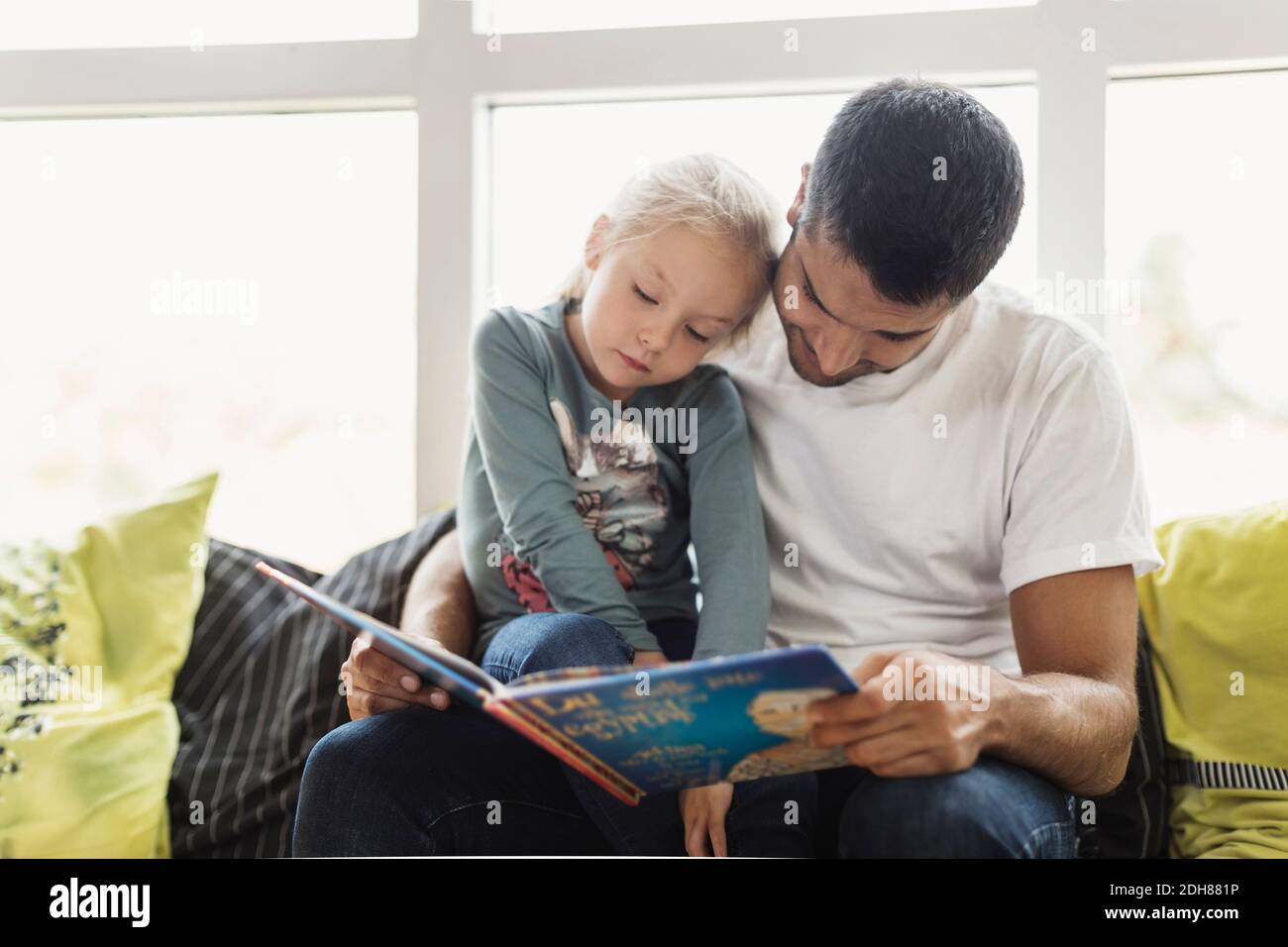 Männlicher Lehrer und weiblicher Schüler lesen Geschichte Buch am Tag Pflegezentrum Stockfoto