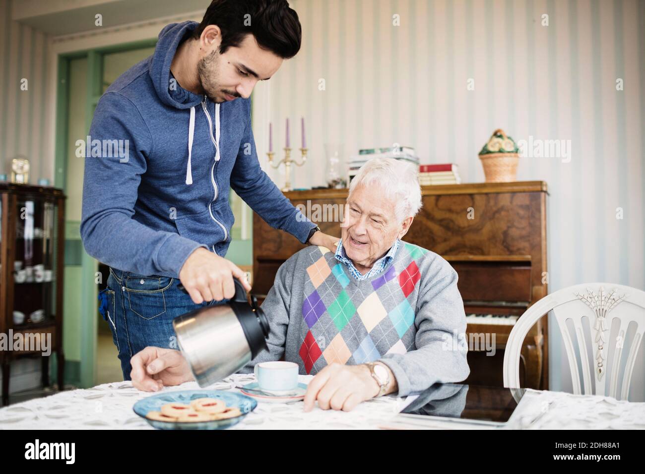 Hausmeister, der älteren Menschen im Pflegeheim Kaffee serviert Stockfoto