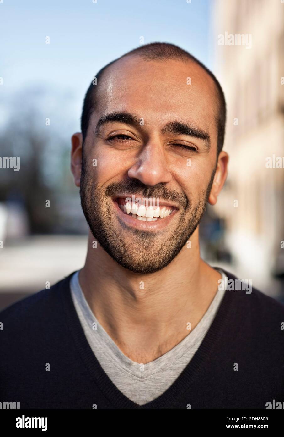 Nahaufnahme eines lächelnden Mannes mit mittlerem Erwachsenenalter, der im Freien zwinkelt Stockfoto