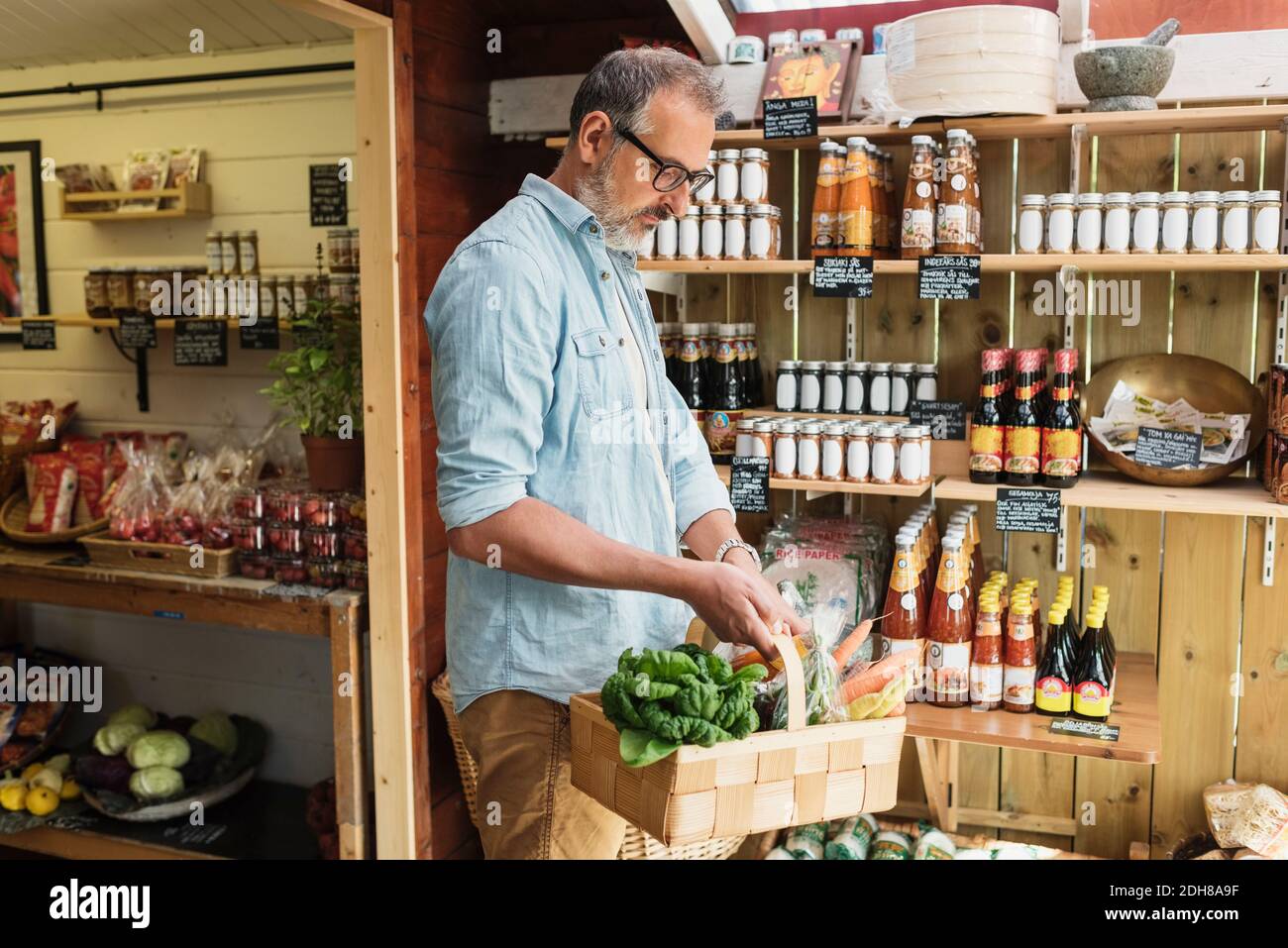 Reifer Mann mit Korb beim Einkaufen im Lebensmittelgeschäft Stockfoto