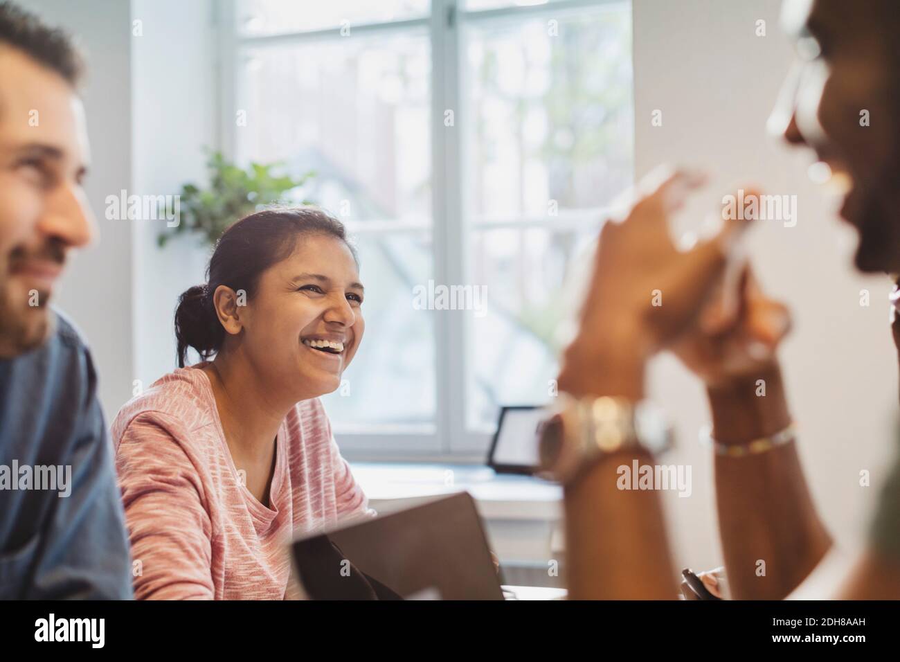 Lächelnde Freunde sitzen im Sprachkurs Stockfoto