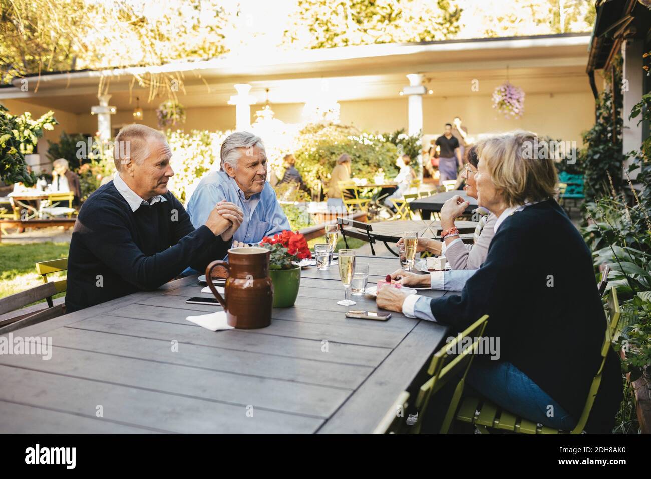 Glückliche ältere Paare diskutieren im Restaurant im Freien Stockfoto