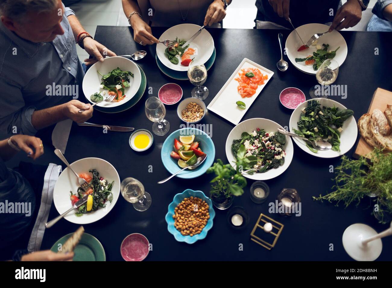 Blick aus der Perspektive von multiethnischen Freunden, die am Tisch essen Stockfoto