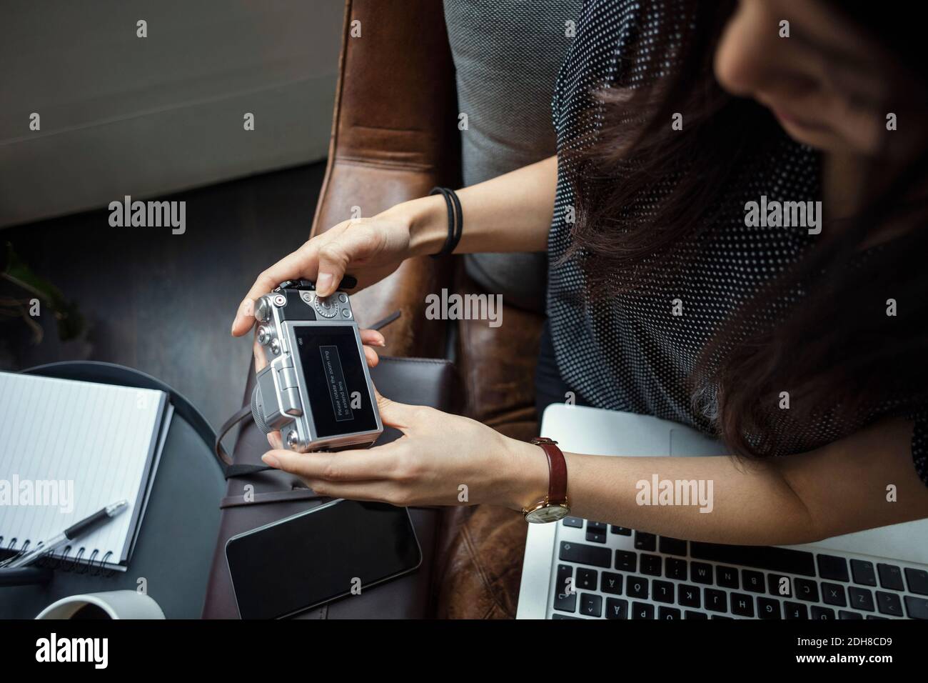 Zugeschnittenes Bild eines Bloggers mit Kamera im Büro Stockfoto