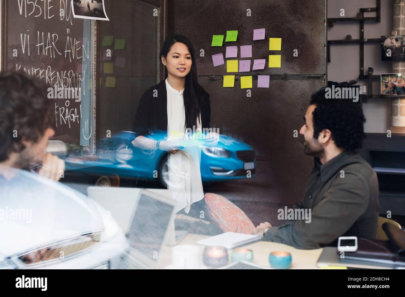 Kreative Geschäftsleute im Büro durch Glasfenster gesehen Stockfoto