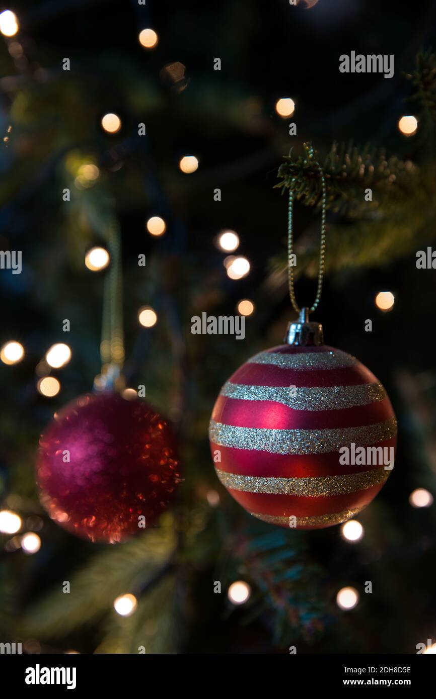 Eine Nahaufnahme der traditionellen Weihnachtsbaumschmuck und Kugeln Hängen an einem künstlichen Baum mit funkelnden Lichterketten und Speicherplatz kopieren Stockfoto