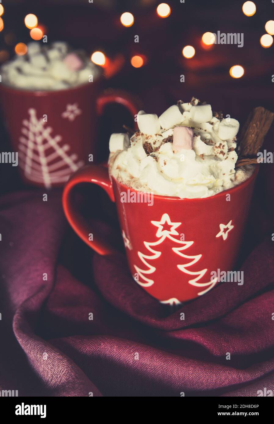 Ein cremiges heißes Schokoladengetränk in einer Weihnachtstasse mit Schlagsahne, Schokolade und Marshmallows mit Platz zum Kopieren Stockfoto