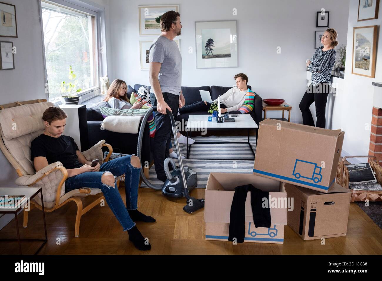 Eltern arbeiten, während Geschwister sitzen im Wohnzimmer bei neu Haus Stockfoto