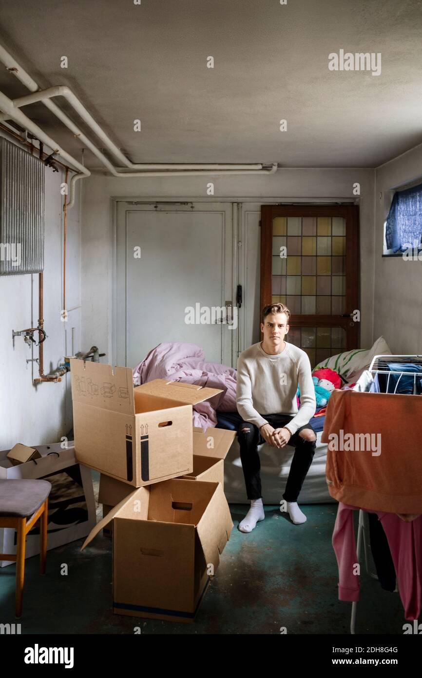 Porträt des Mannes auf dem Bett in neuem Zuhause sitzen Stockfoto