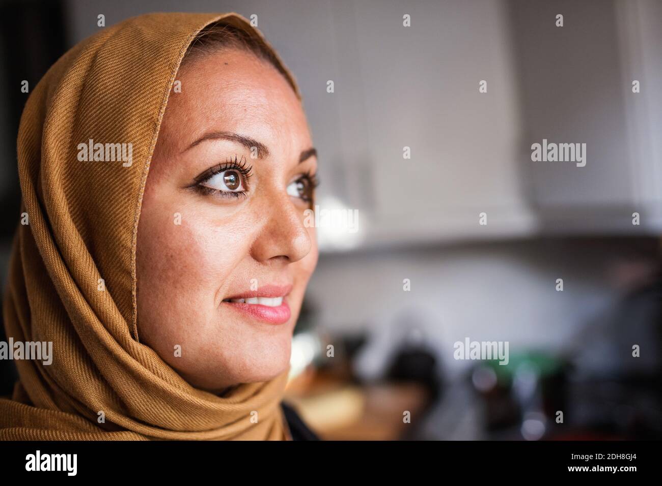 Nachdenkliche Frau in der Küche zu Hause Stockfoto