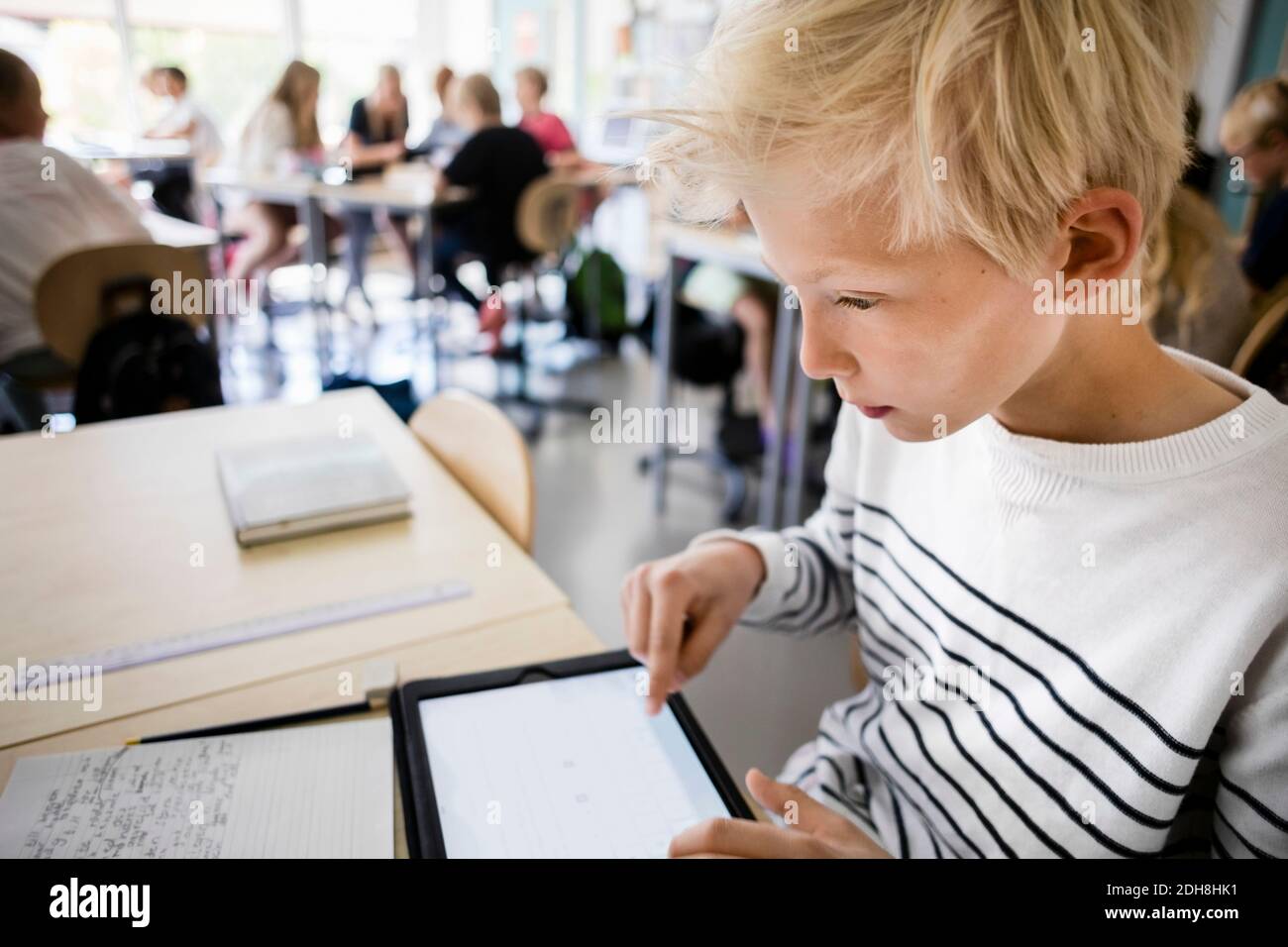 Junge mit digital-Tablette am Schreibtisch im Klassenzimmer Stockfoto