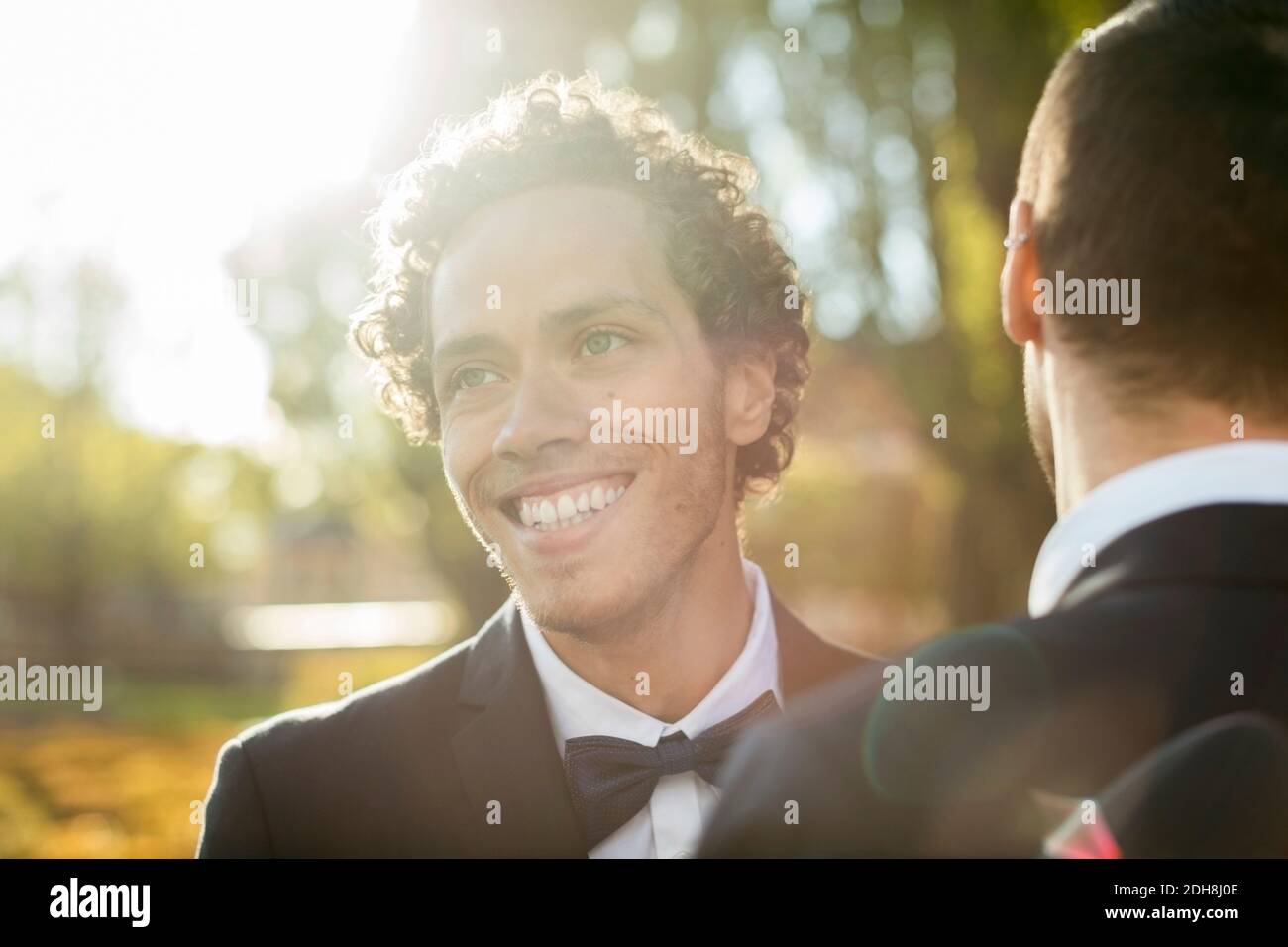 Glücklich newlywed Gay Mann mit Partner am sonnigen Tag Stockfoto