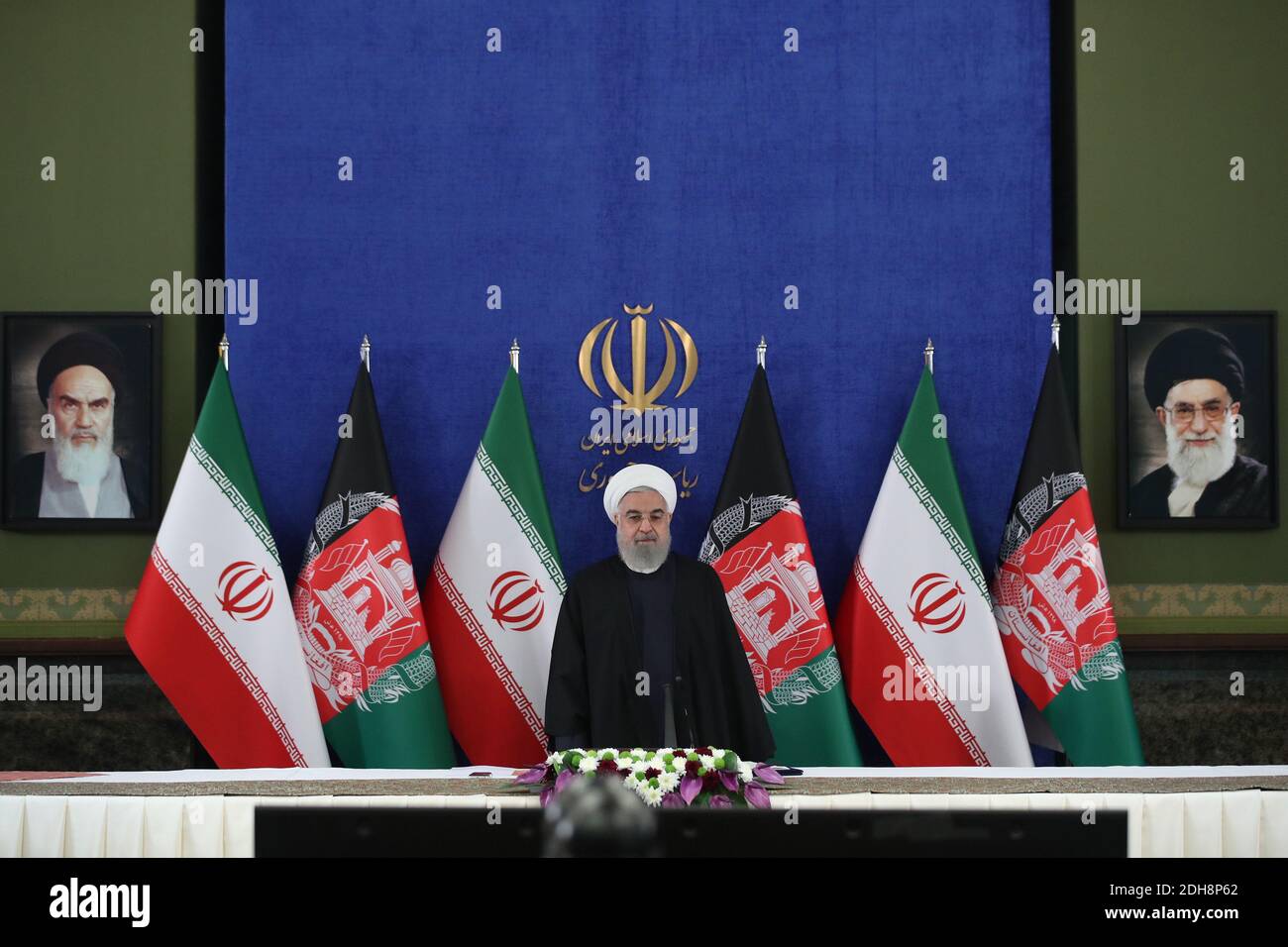 Teheran, Iran. Dezember 2020. Auf diesem Foto, das von der offiziellen Website des Büros der iranischen Präsidentschaft veröffentlicht wurde, steht Präsident Hassan Rohani zu Beginn einer Videokonferenz mit seinem afghanischen Amtskollegen, um die erste Eisenbahnverbindung zwischen den beiden Ländern zu eröffnen, im Präsidentenpalast in Teheran, Iran, Donnerstag, den 10. Dezember, 2020. Die 140 Kilometer lange (90 Meilen) lange Strecke vom östlichen Iran nach Westafghan wird schließlich auf die afghanische Stadt Herat ausgeweitet und stellt eine wichtige Verkehrsverbindung für das Binnenland dar. (Bild: © Iranischer Ratsvorsitz via ZUM Stockfoto