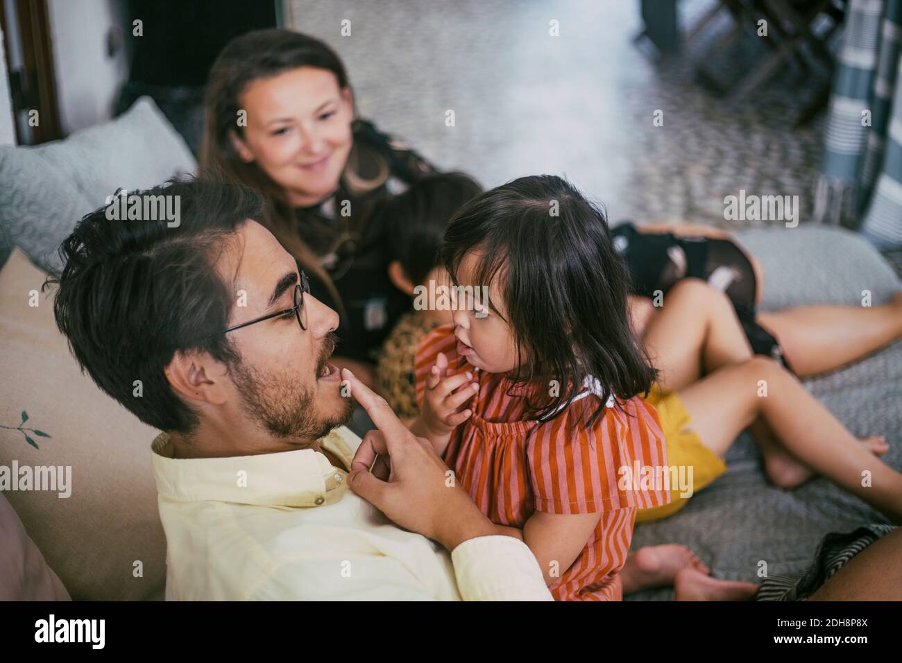 Vater lehrt Tochter mit Behinderung, während auf die Lippen zeigen Sofa Stockfoto