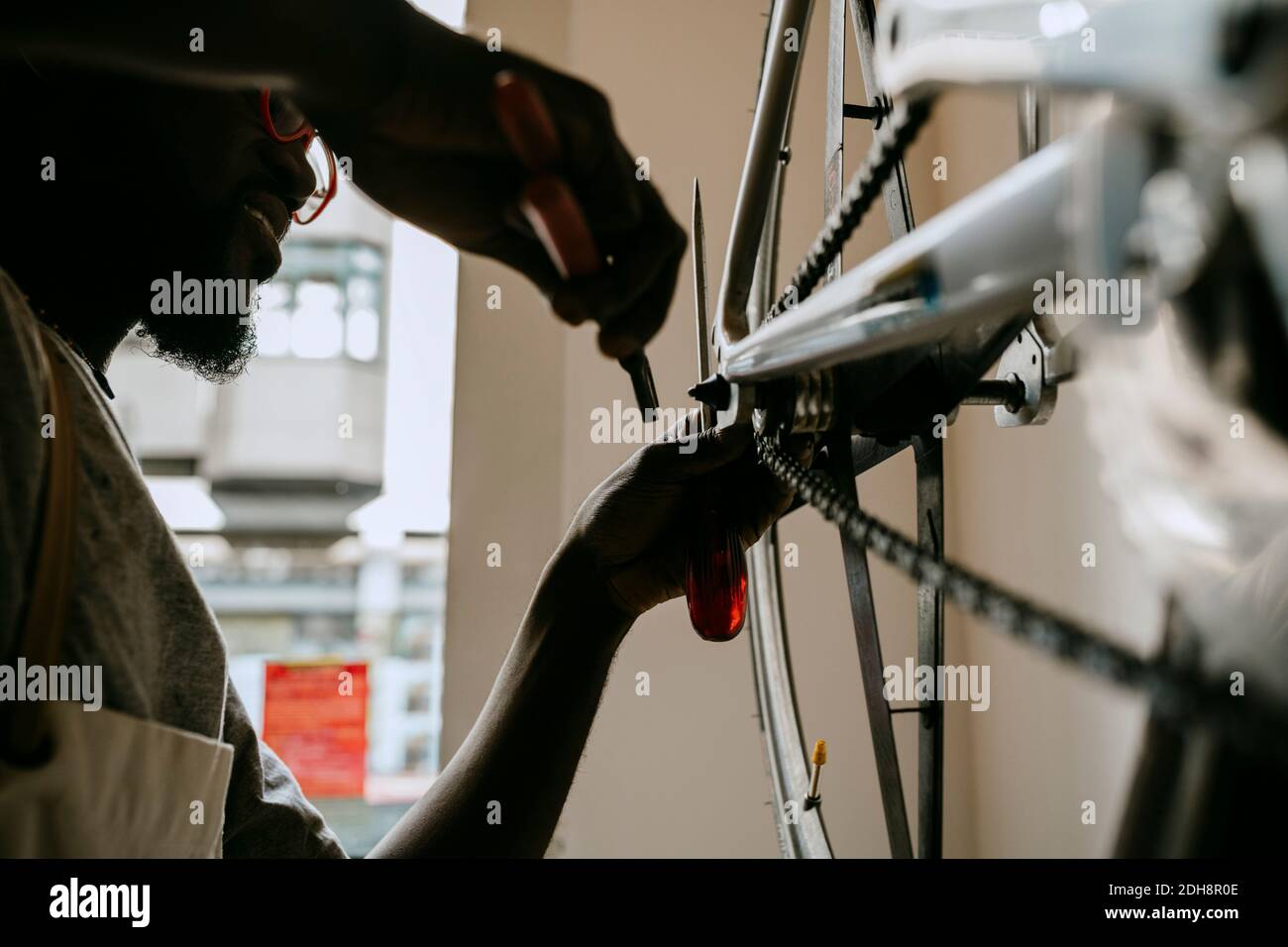 Besitzer mit Handwerkzeug Reparatur Fahrrad in der Werkstatt Stockfoto